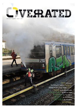 The cover of Overrated Magazine issue #1 showing someone emptyng a fire extinguisher on the metro tracks in front of a painted Amsterdam metro